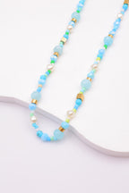 Collier avec cristaux colorés, pierres cylindriques, cubes dorés et perles - BLEU