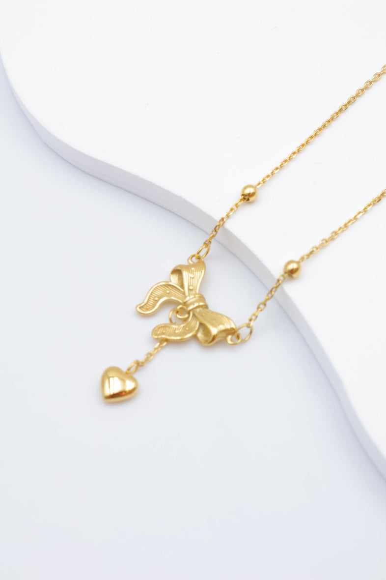 Collier avec motif nœud et pendentif cœur. - DORÉ